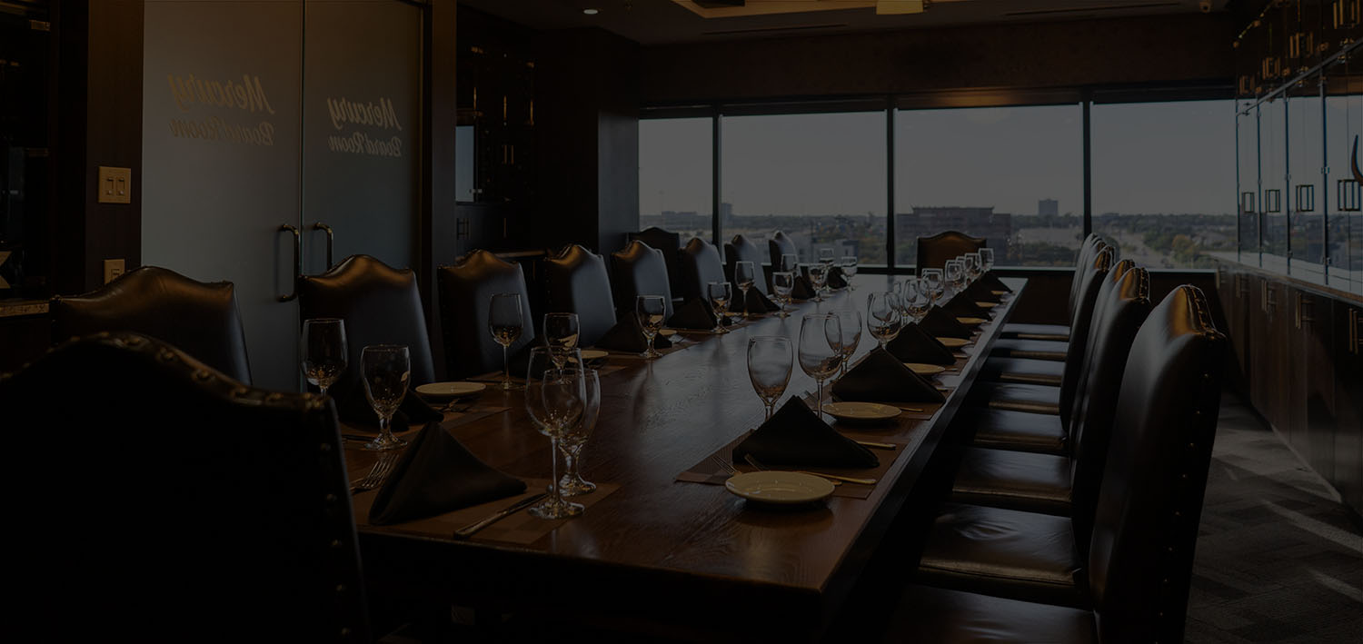 The Boardroom at Mercury Chophouse with the lights low, the private dining table set and the windows dark over Arlington
